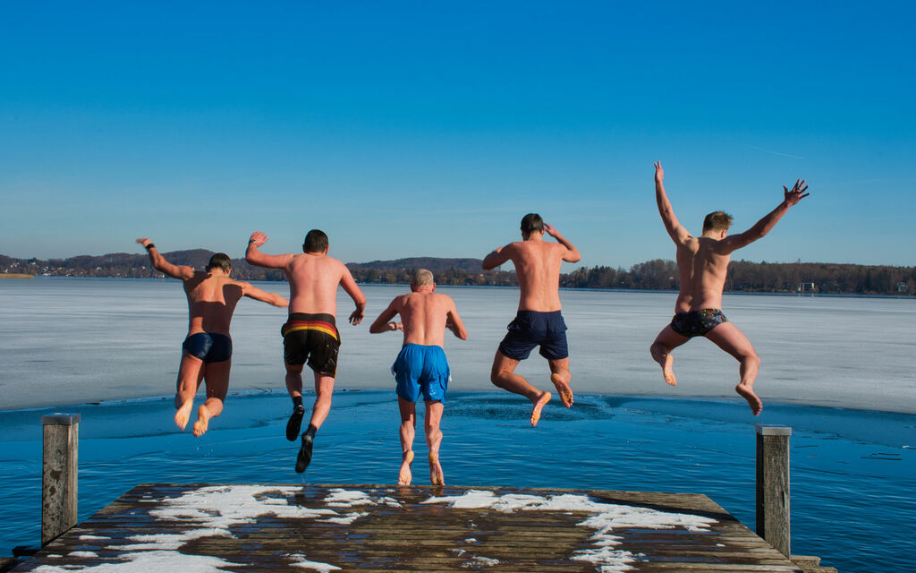 Ice swimming at Wörthsee The winter swimmers jump together from the jetty into the lake