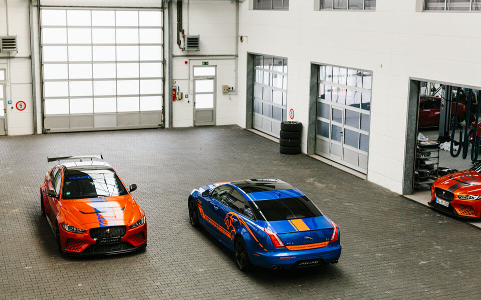 Interview with racing driver Célia Martin Blue and orange Jaguar in a car garage photographed from above