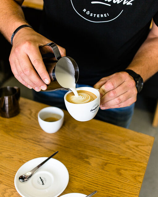 Portrait of the coffee manufacturer Purschwarz Detailed view during coffee preparation: milk foam is poured into a cup of coffee