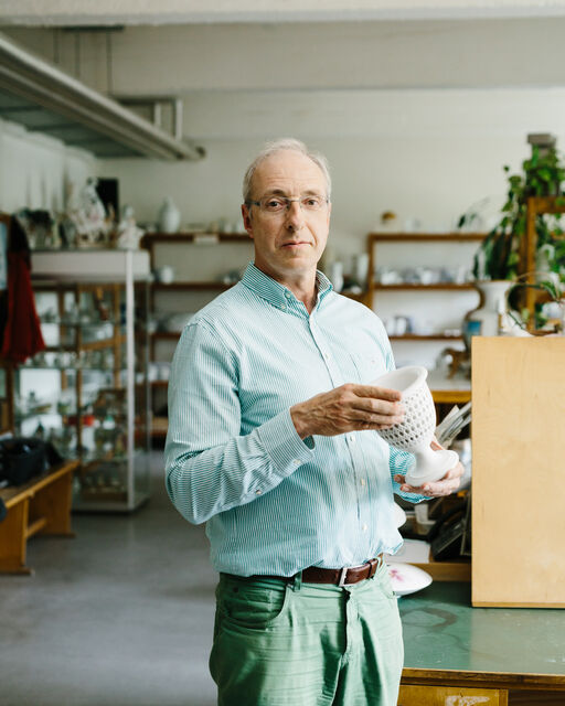 KPM employee Sascha Borowski standing in the studio of KPM and presenting an ANTIKEN ZUCKERKORB