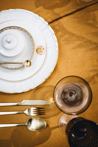 Host without stress: 7 golden rules for a dinner with friends A set of plates, silverware and glasses on a yellow tablecloth
