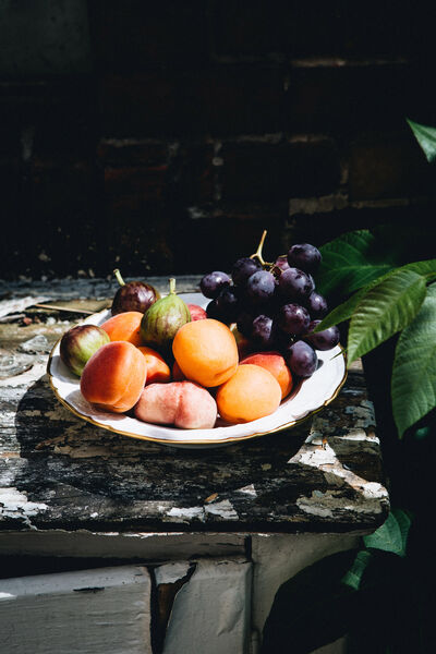 Host without stress: 7 golden rules for a dinner with friends Fruit in a KPM bowl placed on a bench