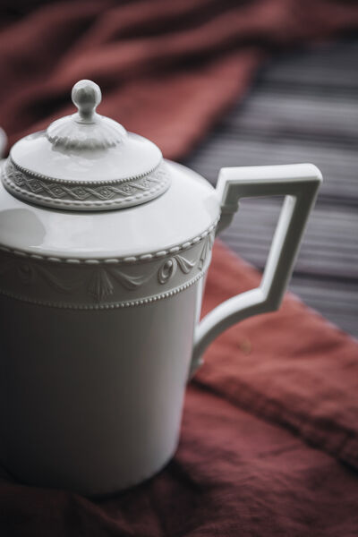 5 delicious recipe ideas: Picnic at Krossinsee with KPM porcelain Close-up of a teapot from the KURLAND collection by KPM on a red picnic blanket on the jetty