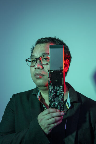 Investor Robin Wu under discussion Blue-exposed portrait photo of the Chinese investor Robin Wu holding electric circuit board