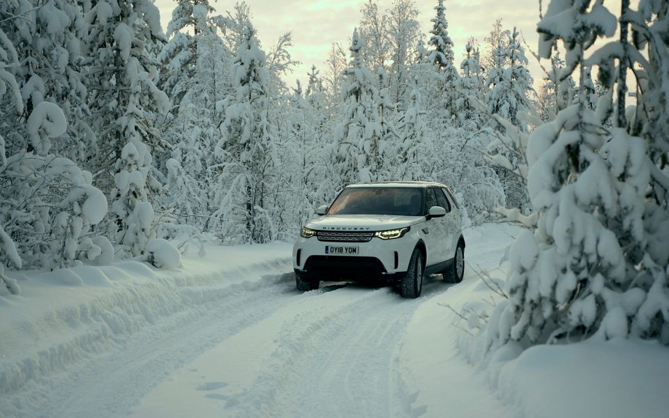 Reindeer experience in Sweden Land Rover Discovery on snow-covered road