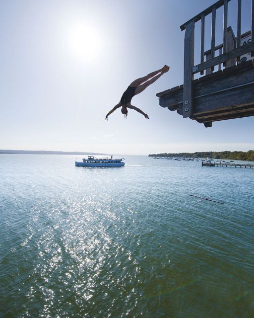 Interview Iris Schmidbauer Iris Schmidbauer jumps from a tower in the background Ship on the Ammersee