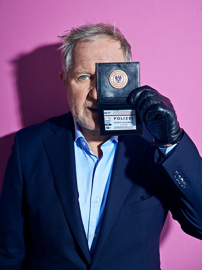 Interview Harald Krassnitzer and Adele Neuhauser for ADAC Portrait of Harald Krassnitzer with badge against a pink background
