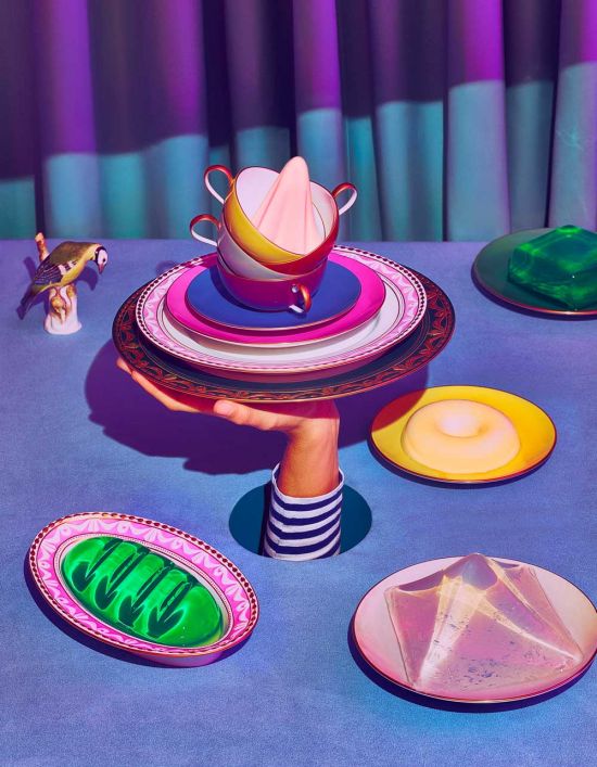 Porcelain tableware creatively combined: View photo gallery in KPM magazine WEISS now Hand holds stacked porcelain plates and cups