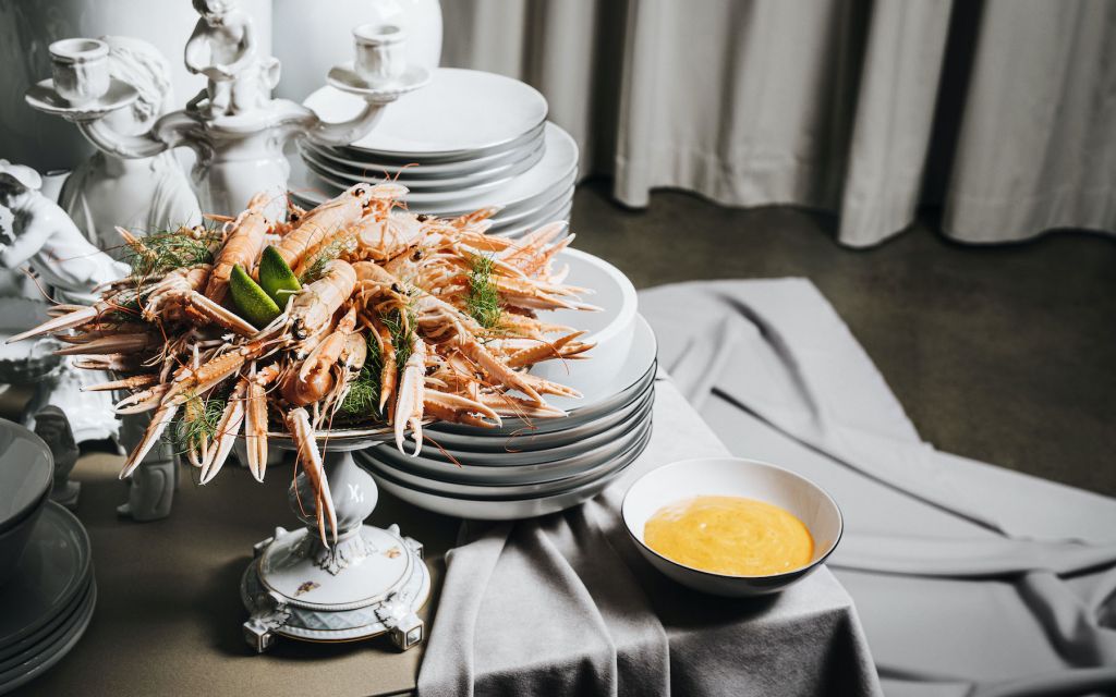 Snack de luxe: Scandinavian delicacies served on royal porcelain from KPM Cooked lobsters with yellow gravy arranged in front of white porcelain plates