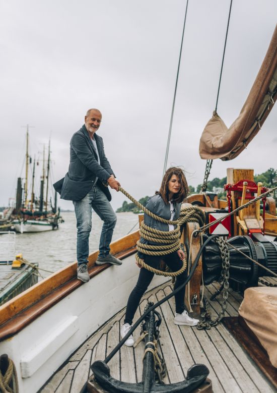 Linda Zervakis and Peter Lohmeyer interviewed for ADAC Motorwelt Peter Lohmeyer wraps Linda Zervakis with ship rope on the deck of a sailboat