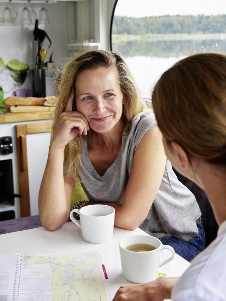 On vacation by houseboat Jessica and Wiebke in the houseboat having coffee
