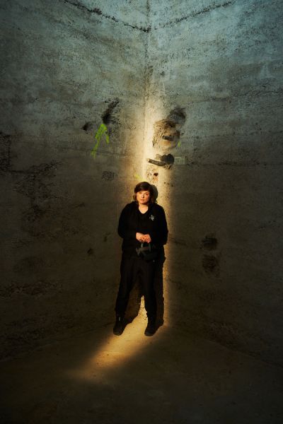 Interview Tina Lorenz for XPLR Media Tina Lorenz standing in a cone of light infront of a wall