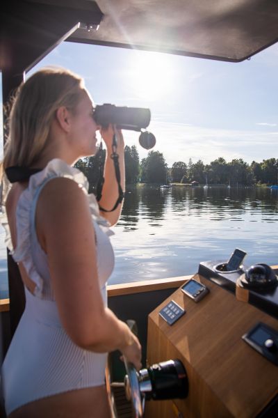 E-boating on Lake Ammersee for SeeMagazin 2021 Young woman at the wheel of an e-boat looks through binoculars