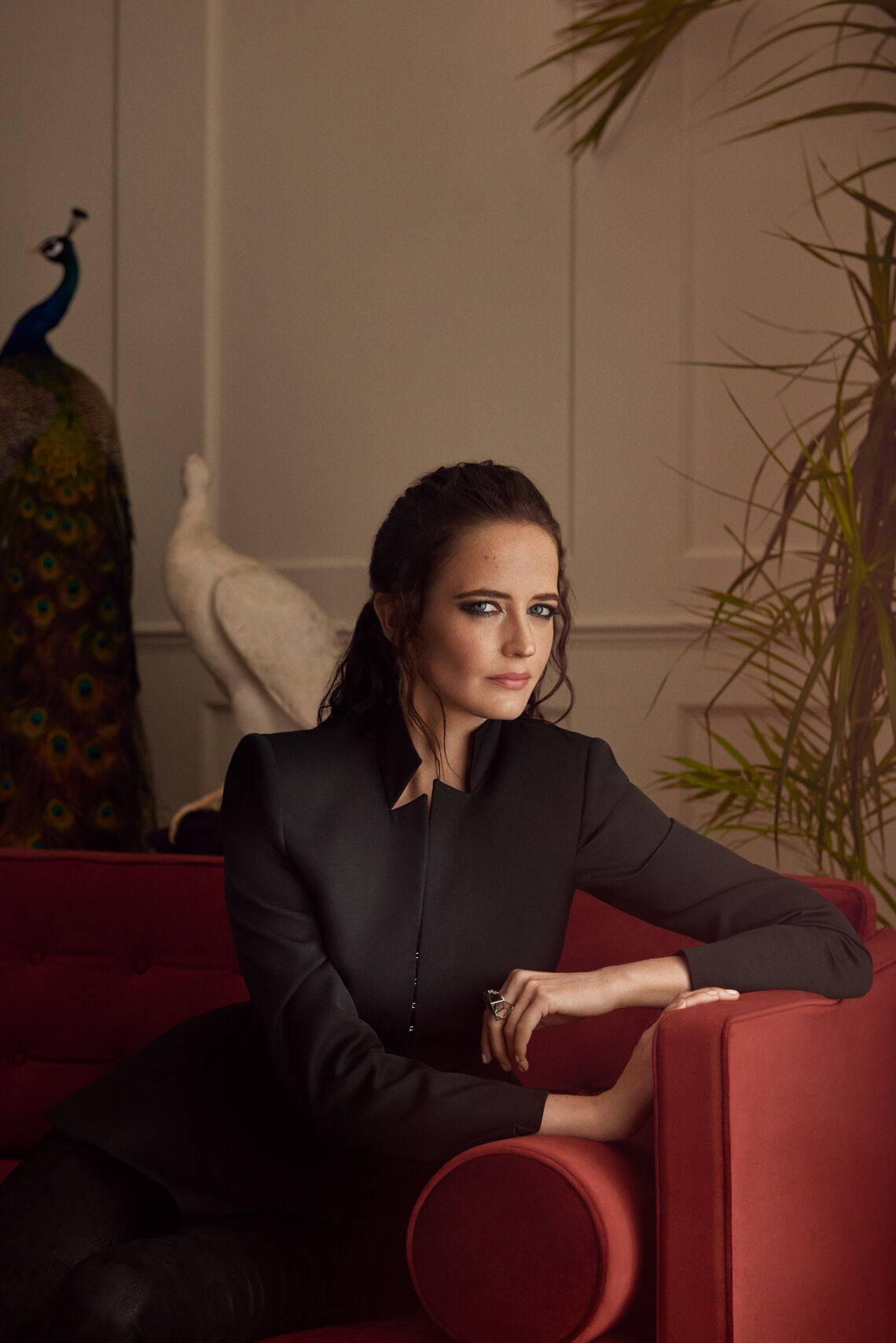 Behind the scenes: Eva Green at the commercial shoot for the Jaguar I-PACE Eva Green wearing a black blouse siting on a red sofa
