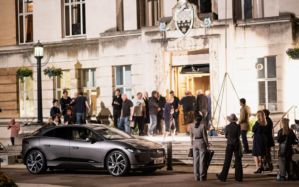 Behind the scenes: Eva Green at the commercial shoot for the Jaguar I-PACE Grey Jaguar I-PACE stands surrounded by several people in front of building