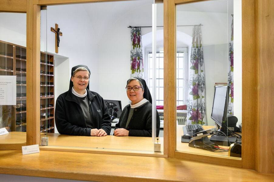 Sacred halls: How Bavarian monasteries move with the times Two nuns stand at the reception of a monastery behind a glass pane