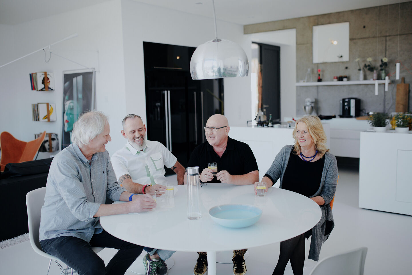 BORA Magazine: Behind-the-scenes at the Homestory in Siegen Three men and one woman sitting together at a round dining table in a kitchen