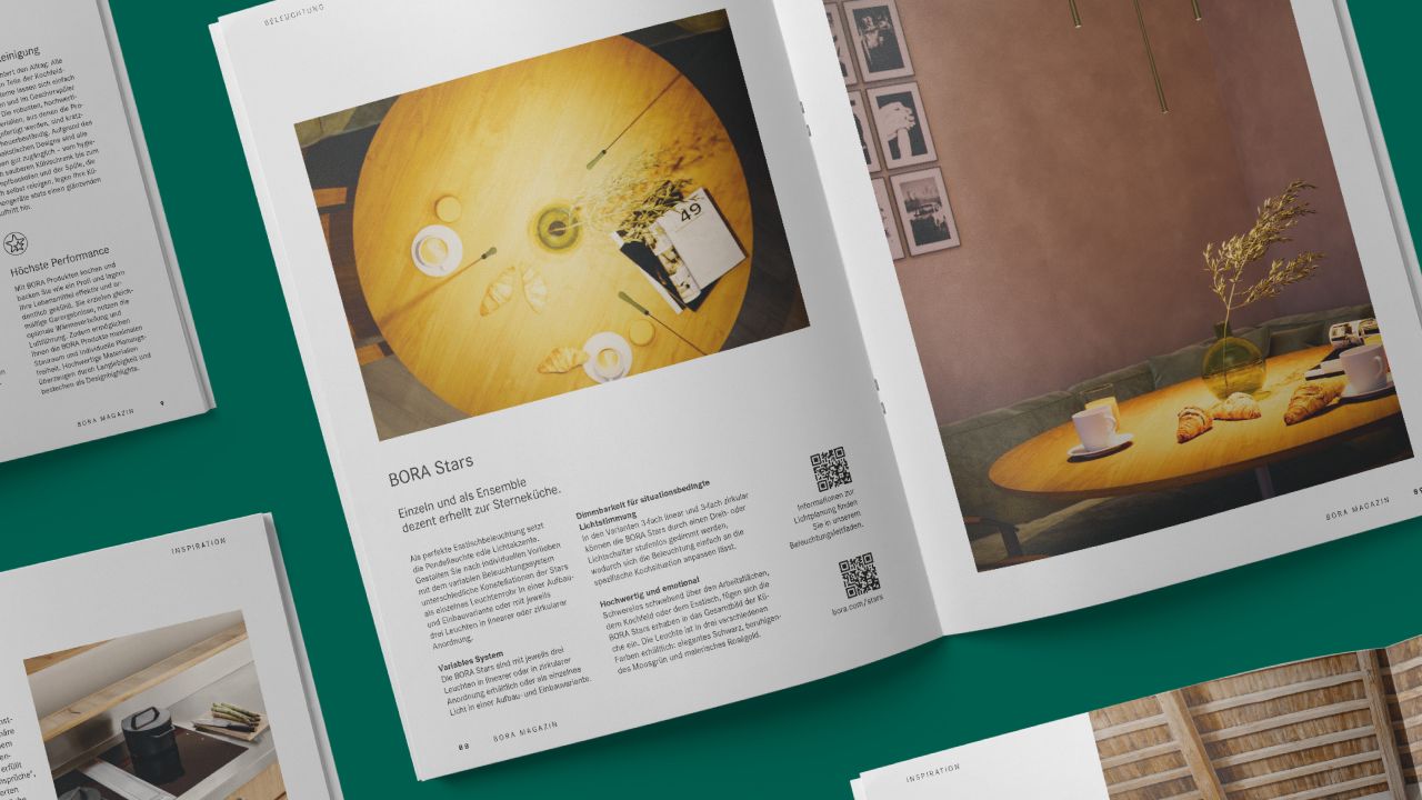 Open double page of BORA magazine with photos of laid tables in a modern living room